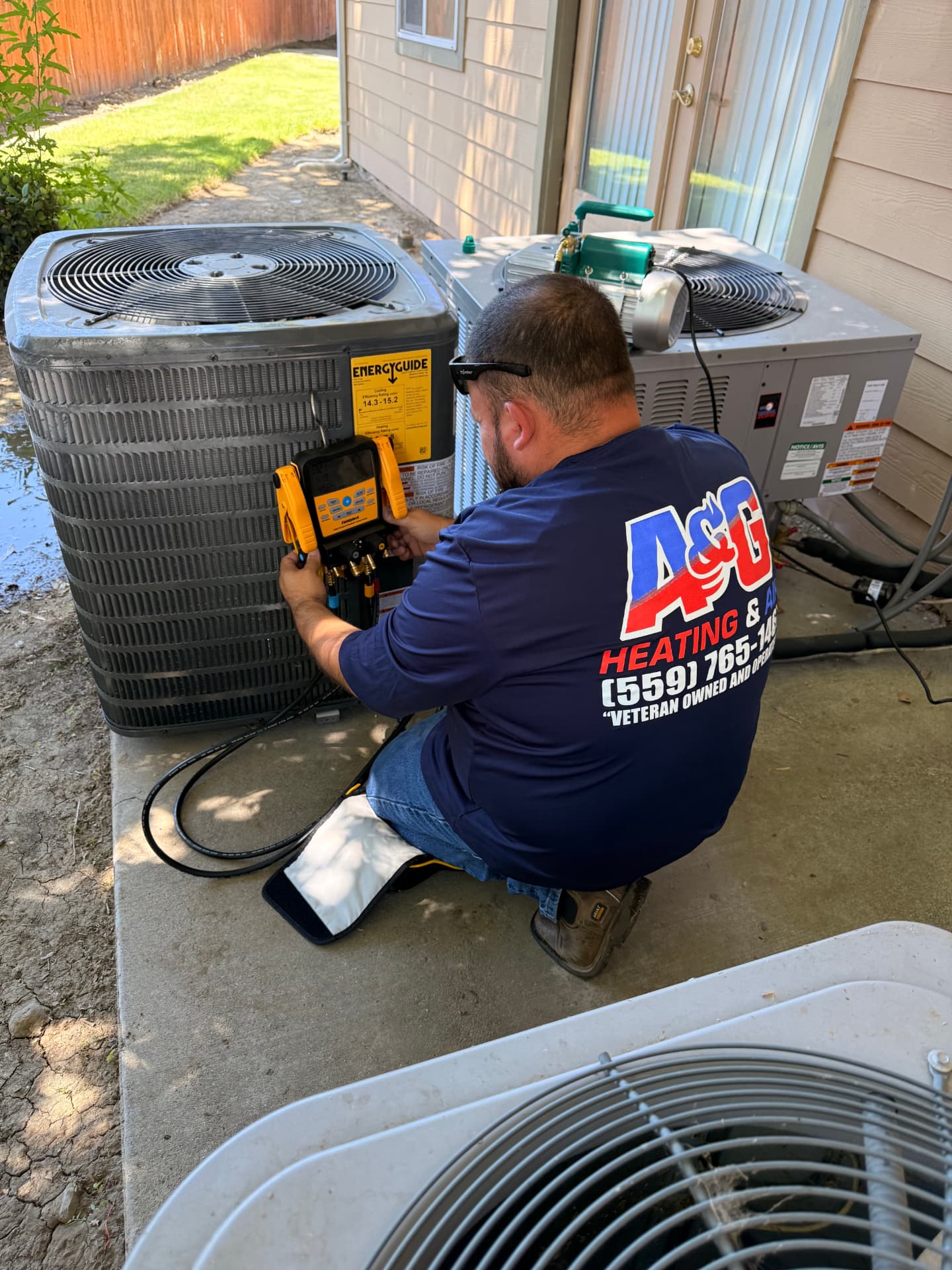 A&G technician checking refrigerant charge on a residential AC condenser