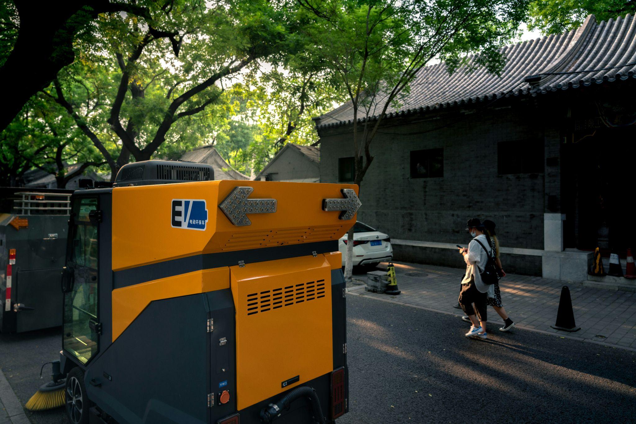 An outdoor street-cleaning vehicle operates near residential buildings, illustrating the importance of home backup generators in Fresno for reliable household power.