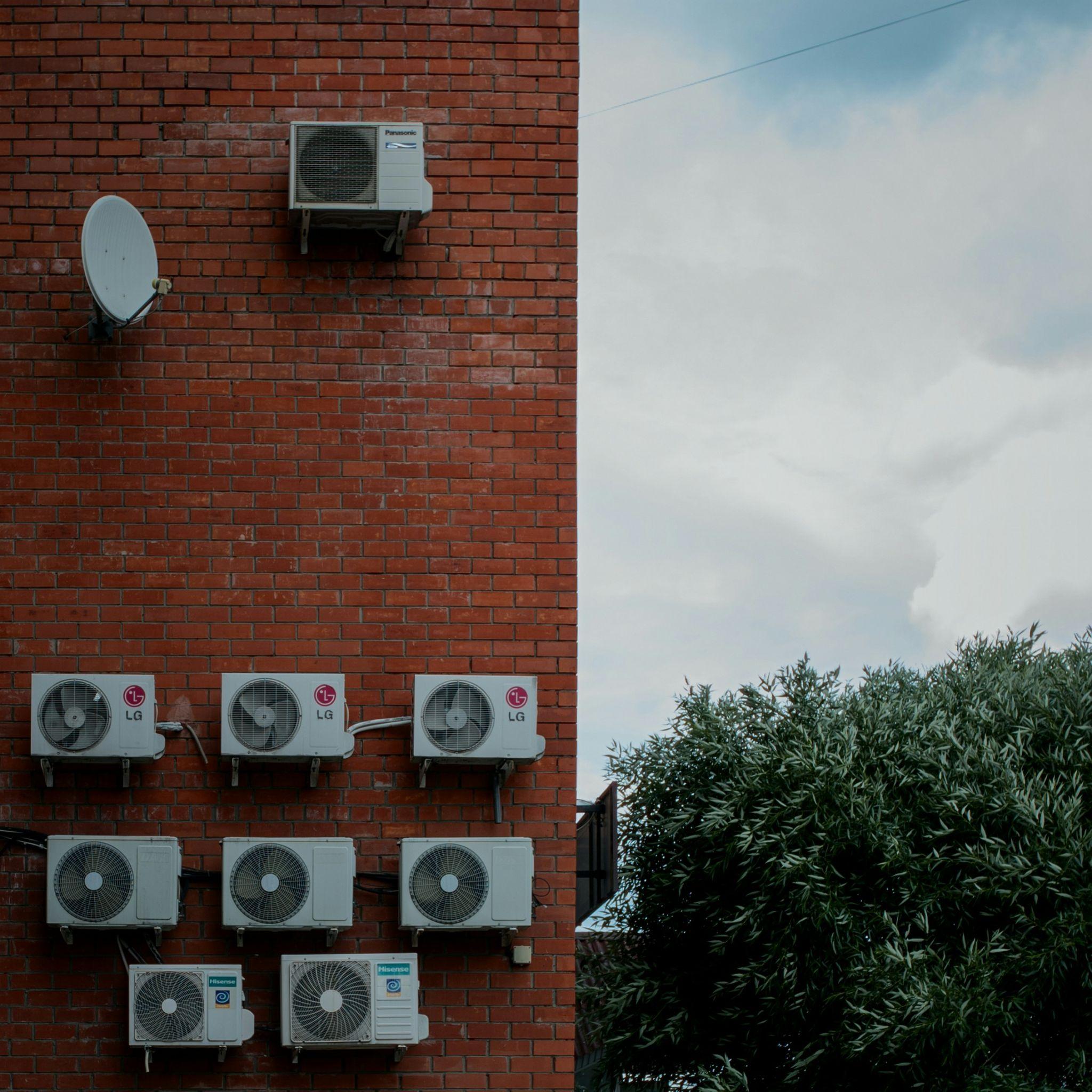 Multiple outdoor air conditioning units mounted on a brick building highlight the importance of commercial HVAC repair in Fresno.